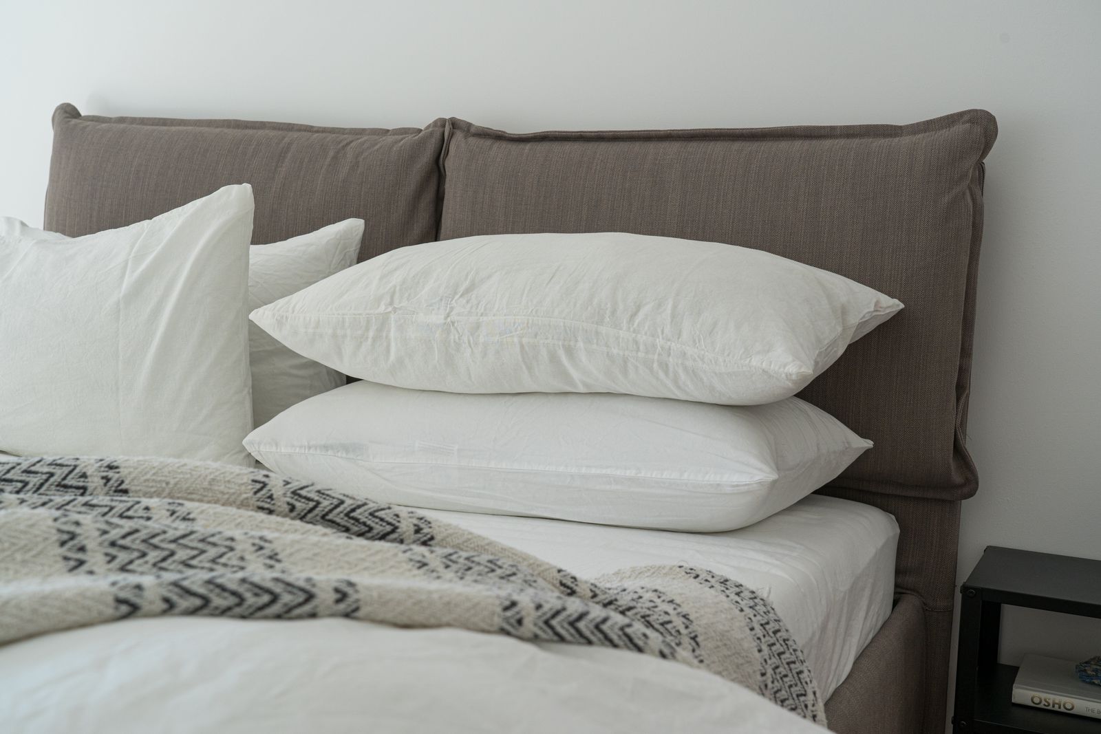 Layered white pillows against a soft upholstered headboard